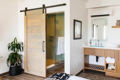 a bathroom with a sliding shower door next to a sink at Surfhouse in Encinitas