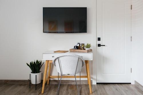 a desk with a chair and a television on a wall at Surfhouse in Encinitas