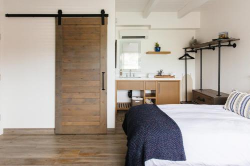 a bedroom with a door leading to a bathroom at Surfhouse in Encinitas