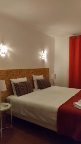 a bedroom with a large white bed with two pillows at Route 2 Torrão in Torrão
