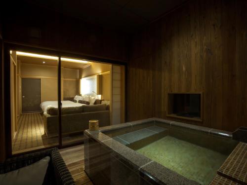 a hotel room with a bath tub with a bed at Saka Hotel Kyoto in Kyoto