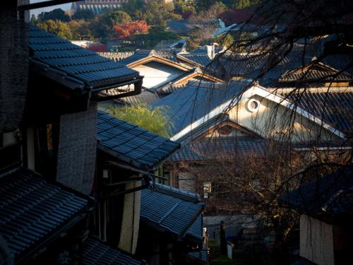 an overhead view of roofs of buildings with trees at Saka Hotel Kyoto in Kyoto