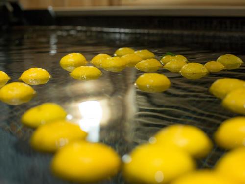 a bunch of yellow balls in a glass vase at Saka Hotel Kyoto in Kyoto