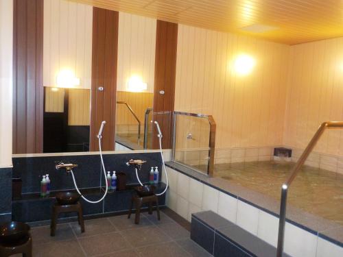 a bathroom with two sinks and two mirrors at Hotel Crown Hills Onahama in Iwaki