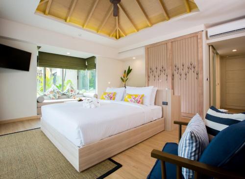 a bedroom with a large white bed and a couch at Mandarava Resort and Spa, Karon Beach in Karon Beach