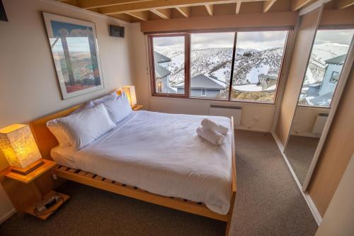 a bedroom with a bed and a large window at Nolyski in Mount Hotham
