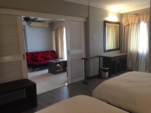 a hotel room with a bed and a couch at D Savoy @ Famosa Melaka in Melaka