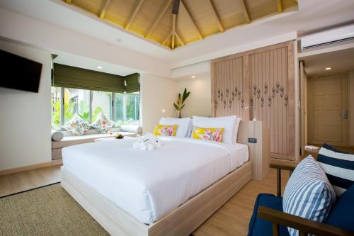 a bedroom with a large white bed in a room at Mandarava Resort and Spa, Karon Beach in Karon Beach