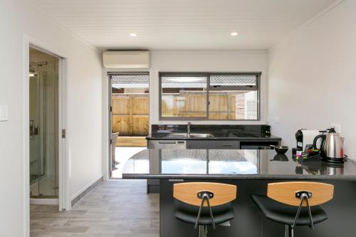 a kitchen with a counter and two stools at eMotel in Taupo