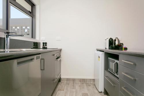 a kitchen with stainless steel appliances and a sink at eMotel in Taupo