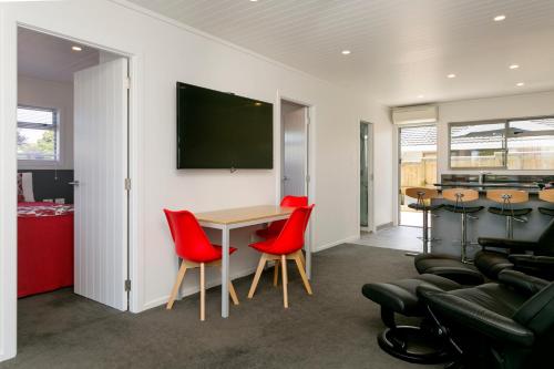 a meeting room with red chairs and a table at eMotel in Taupo