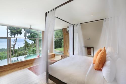 a bedroom with a bed and a large window at Ambong Pool Villas - Private Pool in Pantai Cenang