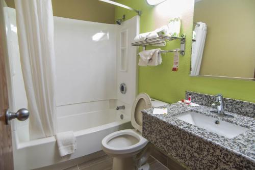 a bathroom with a sink and a toilet and a mirror at Economy 7 Inn Chesapeake - Portsmouth in Chesapeake