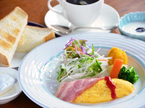 a white plate with food on a table at Fukuno Town Hotel A・Mieux in Nanto