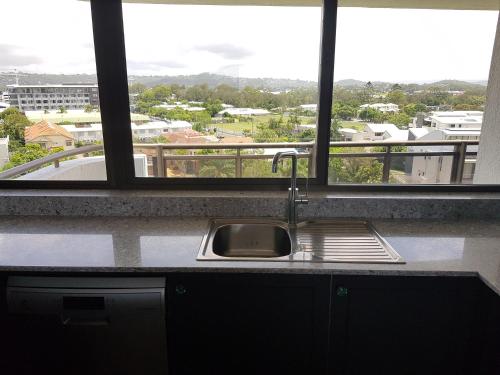 a kitchen counter with a sink and a window at Trafalgar Towers in Maroochydore