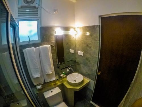 a bathroom with a sink and a toilet and a mirror at Chaminrich Homestay in Kandy