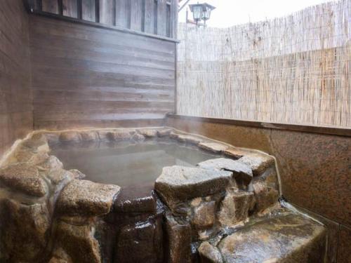 a pool of water in a stone tub in a building at Kindayu in Shibukawa