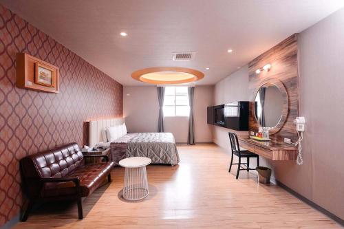 a bedroom with a bed and a couch and a table at Guest Motel- Zhongli Branch in Pingzhen
