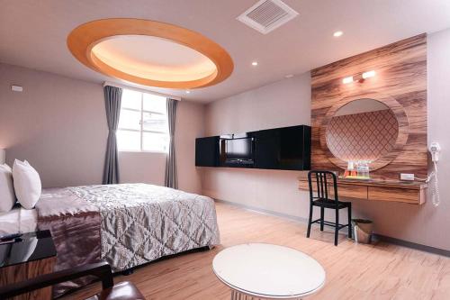 a bedroom with a bed and a table and a desk at Guest Motel- Zhongli Branch in Pingzhen