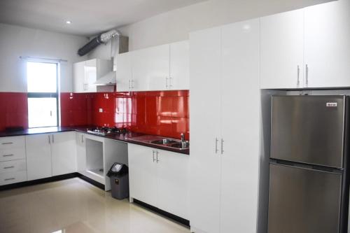 a kitchen with red and white cabinets and a refrigerator at Best View Apartments in Nadi
