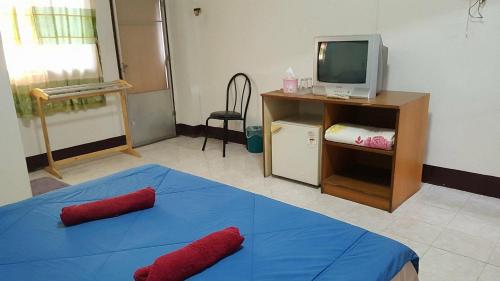 a room with a blue bed and a television at LP Apartment in Sakon Nakhon