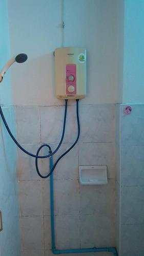 y baño con ducha y manguera azul. en LP Apartment, en Sakon Nakhon