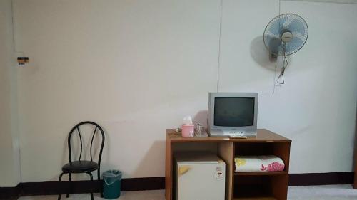 Habitación con escritorio, ordenador y ventilador. en LP Apartment en Sakon Nakhon