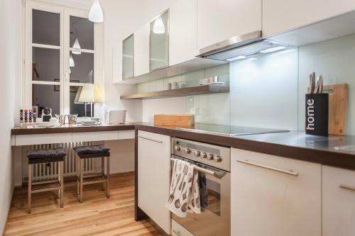 een keuken met witte kasten en een kookplaat oven bij Świętojańska Old Town Deluxe Apartament by BookingHost in Warschau
