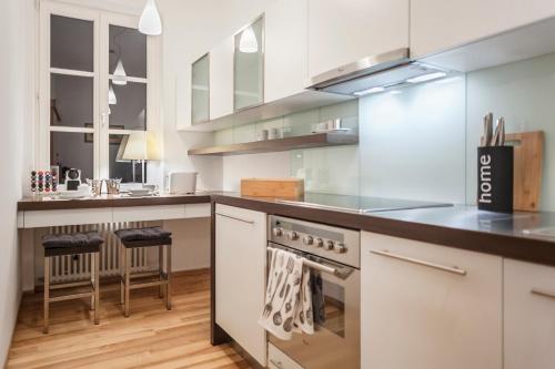 a kitchen with white cabinets and a stove top oven at Świętojańska Old Town Deluxe Apartament in Warsaw