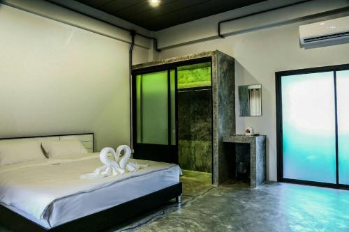 a bedroom with a bed and a large window at The Ele Hotel Ranong - SHA Extra Plus in Ranong