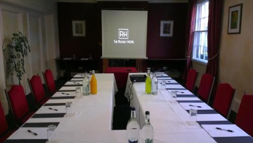 a conference room with a long table with wine bottles at The Rugby Hotel in Rugby