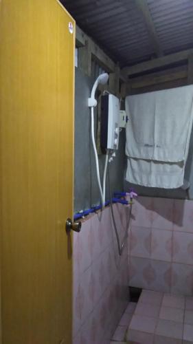 a shower in a bathroom with a yellow door at Batad Lhorens Inn and Restaurant in Banaue