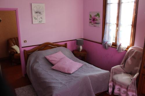 - une chambre rose avec un lit et 2 oreillers roses dans l'établissement le balcon du parc, à Laubressel