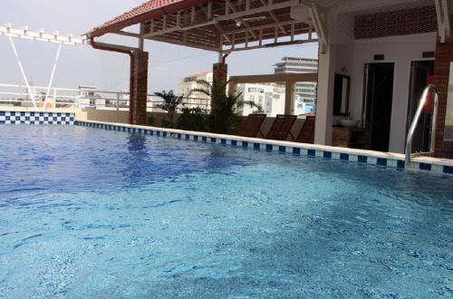 una piscina en un hotel con sombrilla en Ananas Family Hotel en Ho Chi Minh