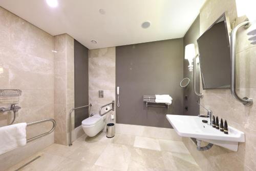 a bathroom with a toilet and a sink and a mirror at Sueno Hotels Deluxe Belek in Belek