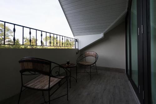 two chairs and a table on a balcony at Merchant House Chiangmai in Chiang Mai