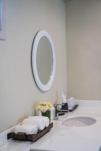 a white bathroom with a sink and a mirror at Merchant House Chiangmai in Chiang Mai