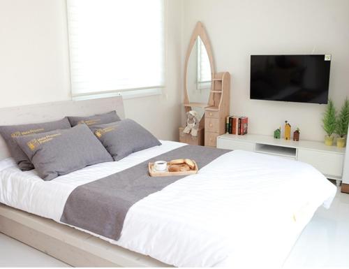 a bedroom with a large white bed and a tv at Saint Paul De Vence in Damyang
