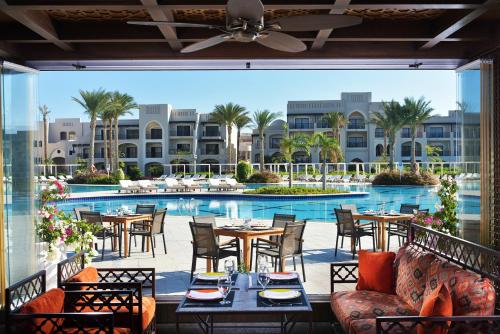 a patio with tables and chairs in front of a pool at Steigenberger Alcazar in Sharm El Sheikh