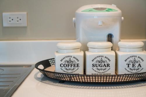 a shelf with four jars of coffee on a counter at Merchant House Chiangmai in Chiang Mai