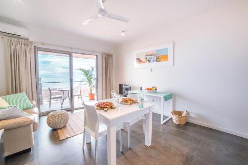 a living room with a white dining room table with a view at Onslow Beach Resort in Onslow