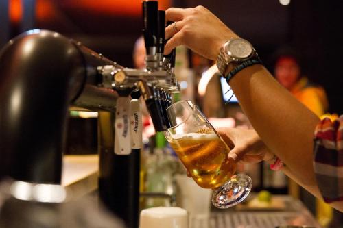a person pouring a drink into a glass at Nordseehotel Kröger in Langeoog