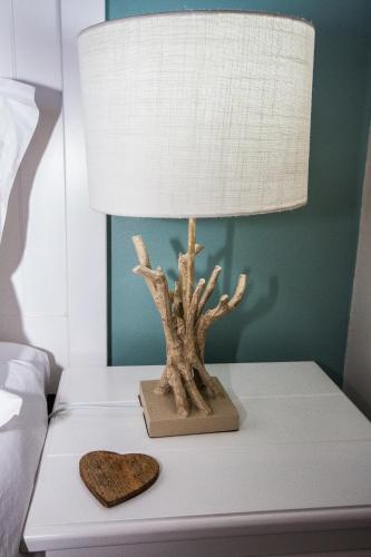a lamp on a bedside table with a cedar tree on it at Little Rock Guesthouse in Jongensfontein