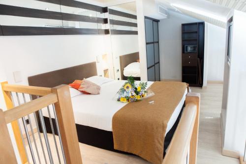 Un dormitorio con una cama y una mesa con flores. en Résidence Villa d'Elsa, en Juan-les-Pins