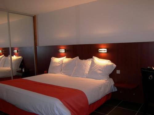 a hotel room with a large bed with white pillows at Hostellerie Del Matin Calme in Montverdun