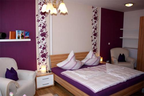 マルヒョーにあるFerienwohnung Malchow SEE 7231の紫の壁のベッド1台、白い枕が備わるベッドルーム1室が備わります。