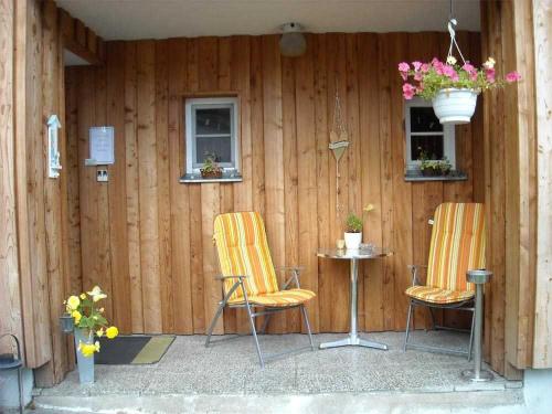 NepperminにあるFerienwohnung Neppermin USE 2771の木製の壁の前に椅子2脚とテーブル