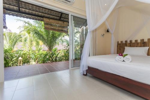 1 dormitorio con cama y ventana grande en Le Forest Resort en Phu Quoc