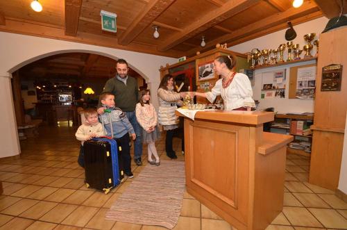 a group of people standing around a counter in a kitchen at Hotel Albe in Rocca Pietore