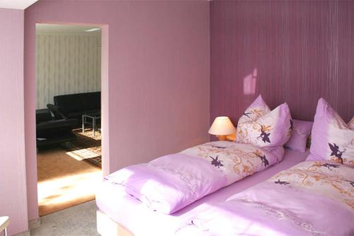 ヴァーレンにあるFerienwohnung Waren SEE 8911の紫の壁のベッドルーム1室(大型ベッド1台付)